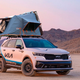 A photo of a Kia SUV with a fold-out Roofnest tent on top.